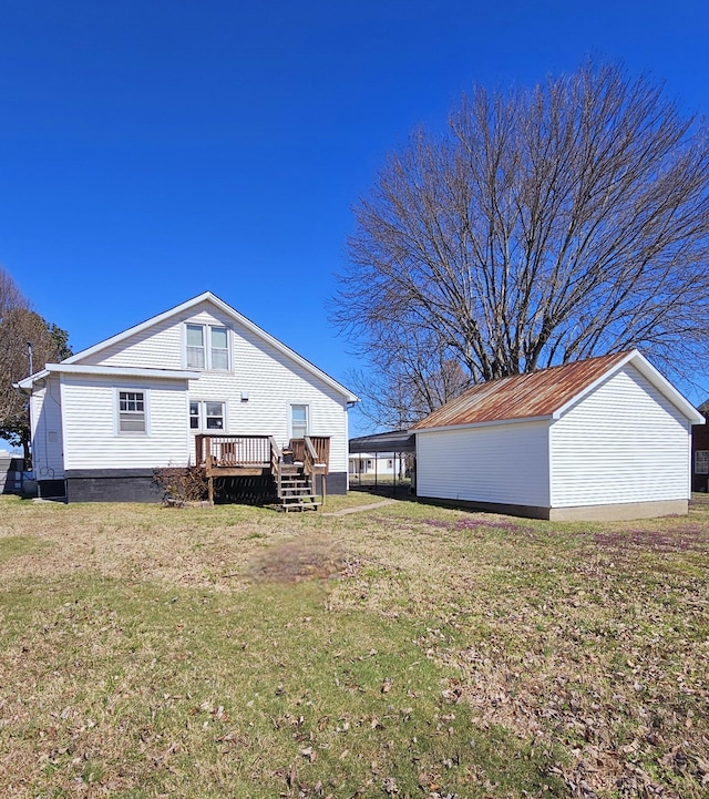 rear view of property with a wooden deck and a lawn