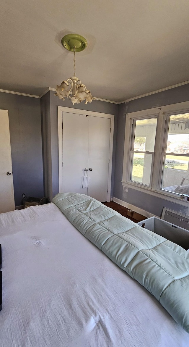 bedroom featuring a closet, an inviting chandelier, and ornamental molding