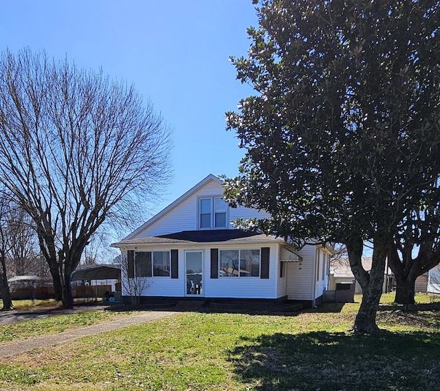 view of front of home featuring a detached carport and a front yard