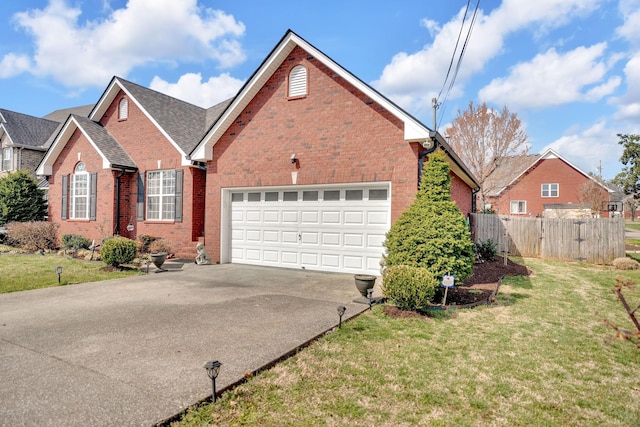 view of front of property with brick siding, driveway, a front yard, and fence