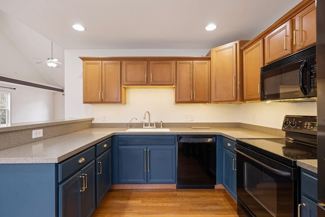 kitchen featuring black appliances, a sink, blue cabinetry, a peninsula, and ceiling fan