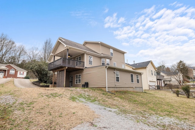 view of side of home featuring a ceiling fan and fence