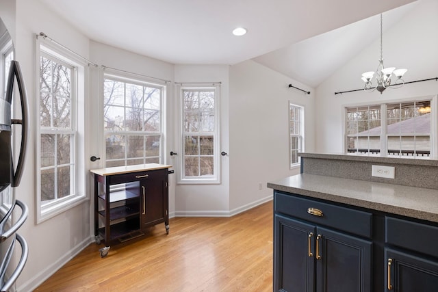 kitchen with vaulted ceiling, a healthy amount of sunlight, light wood finished floors, and pendant lighting