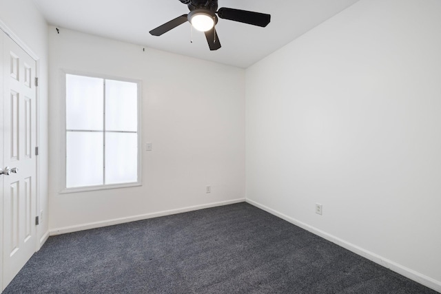 unfurnished room featuring a ceiling fan, baseboards, and dark carpet