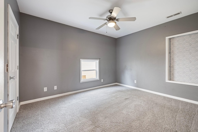 carpeted empty room featuring visible vents, baseboards, and a ceiling fan