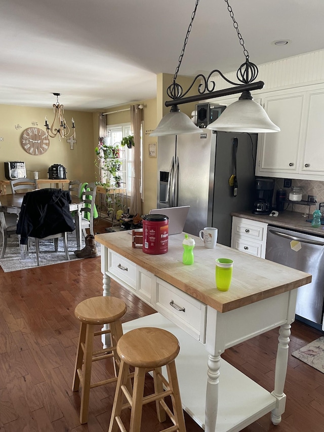 kitchen with dark wood-style floors, white cabinets, butcher block counters, and stainless steel appliances