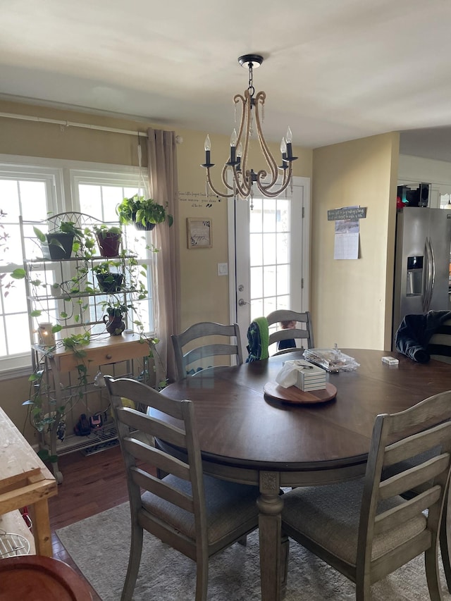 dining space featuring a notable chandelier and wood finished floors