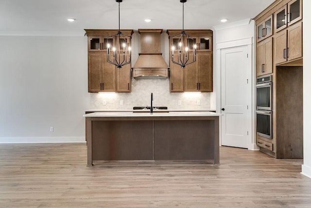 kitchen featuring custom exhaust hood, tasteful backsplash, crown molding, and an inviting chandelier