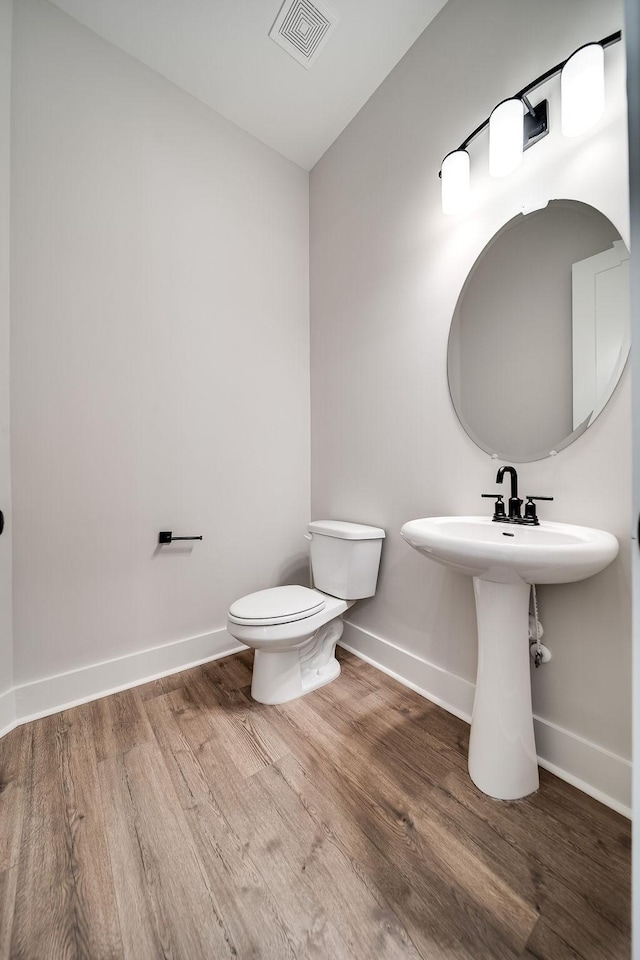 bathroom featuring visible vents, baseboards, and wood finished floors