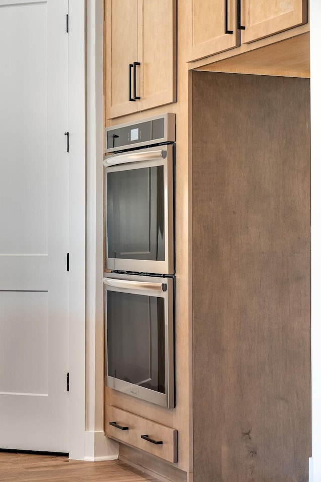 kitchen with double oven and wood finished floors