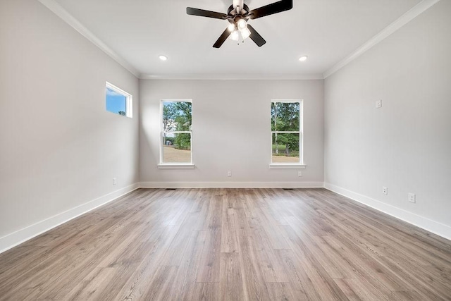 empty room with baseboards, plenty of natural light, wood finished floors, and crown molding