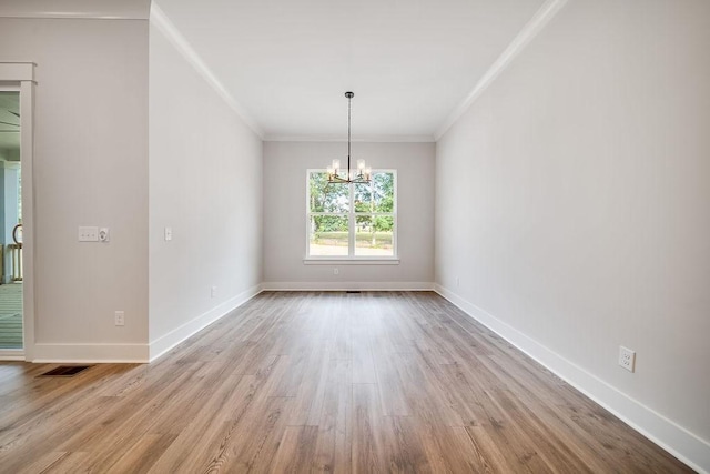 unfurnished dining area featuring visible vents, wood finished floors, crown molding, baseboards, and a chandelier