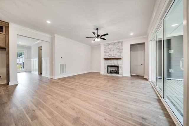 unfurnished living room featuring a ceiling fan, a fireplace, visible vents, and light wood-type flooring