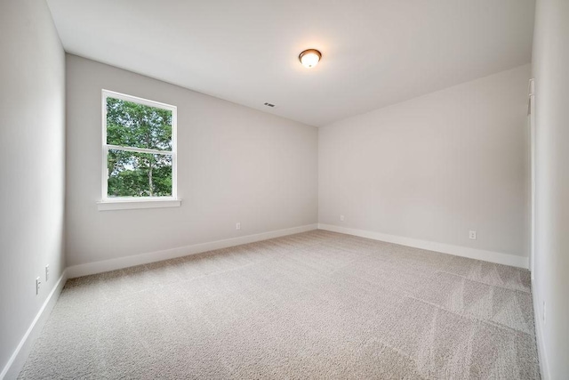 carpeted spare room featuring baseboards