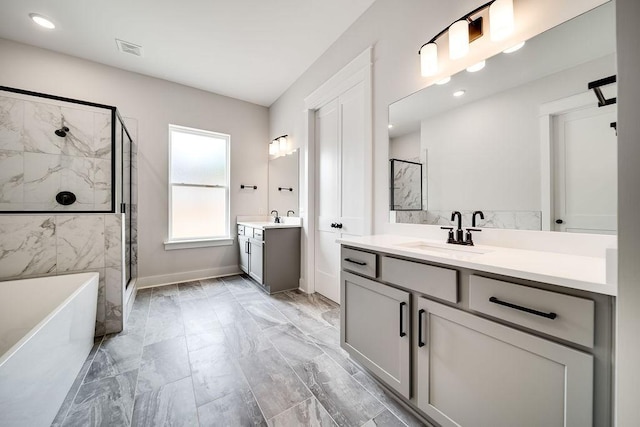 full bathroom with visible vents, a freestanding tub, marble finish floor, a sink, and a shower stall