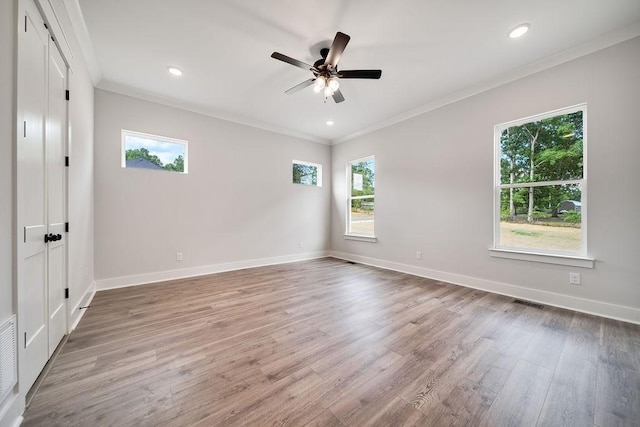 empty room featuring recessed lighting, wood finished floors, baseboards, and ornamental molding