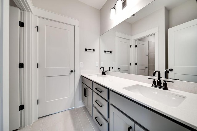 full bathroom with double vanity, tile patterned flooring, and a sink