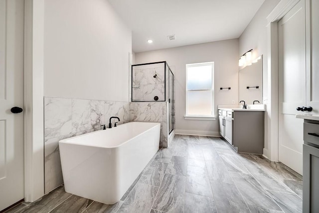 full bathroom with a freestanding tub, visible vents, a stall shower, tile walls, and vanity