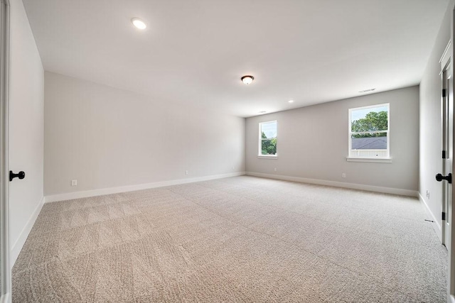 unfurnished room featuring visible vents, recessed lighting, light colored carpet, and baseboards