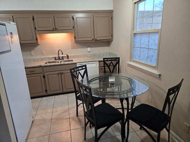 kitchen with baseboards, light tile patterned floors, gray cabinets, white appliances, and a sink