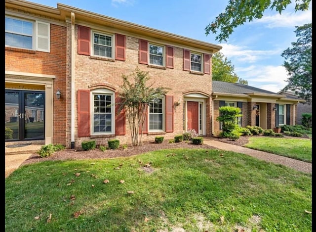 view of front of house featuring brick siding and a front yard