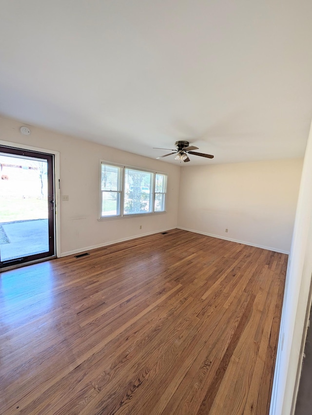 unfurnished room with visible vents, baseboards, a ceiling fan, and wood finished floors