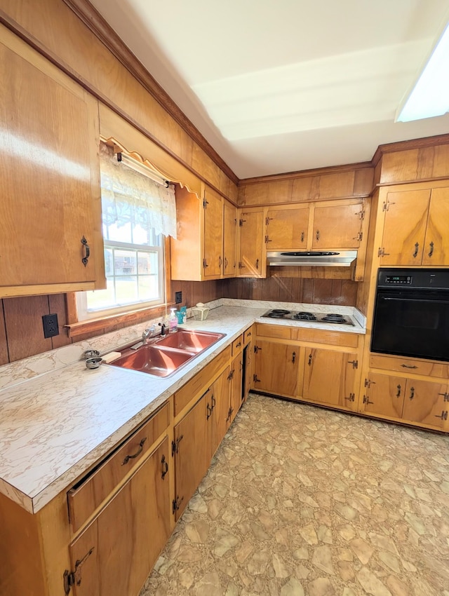 kitchen featuring black oven, under cabinet range hood, light countertops, electric stovetop, and a sink