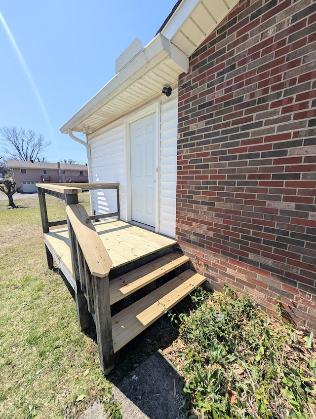 entrance to property with brick siding and a deck