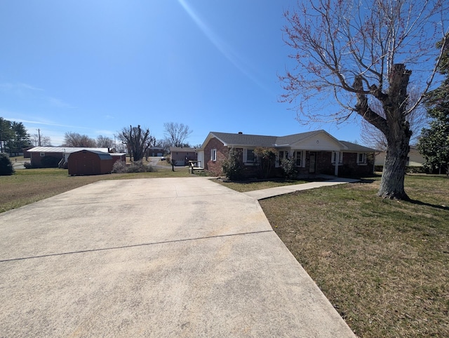 ranch-style home featuring brick siding, concrete driveway, and a front lawn