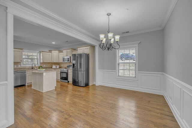 kitchen featuring visible vents, a notable chandelier, cream cabinetry, a sink, and stainless steel appliances