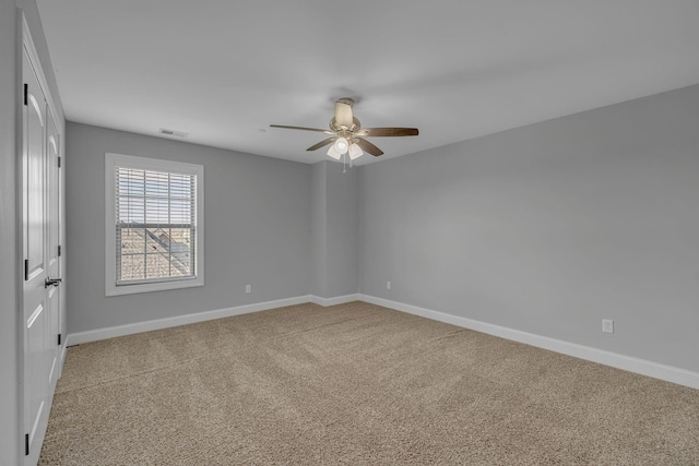 unfurnished room featuring baseboards, visible vents, carpet floors, and ceiling fan