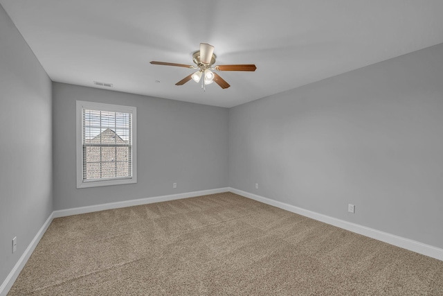 spare room with visible vents, baseboards, carpet, and ceiling fan