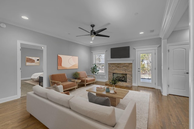 living area featuring a fireplace, wood finished floors, and ornamental molding