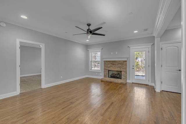 unfurnished living room with crown molding, wood finished floors, a fireplace, and baseboards