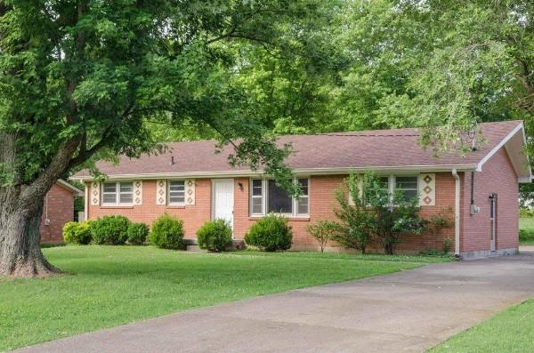 ranch-style home with brick siding and a front yard