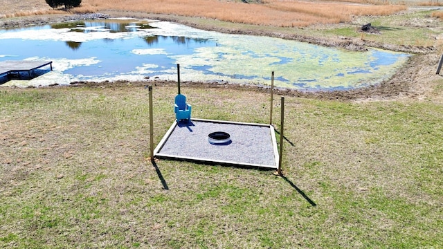 entry to storm shelter featuring a lawn and a water view