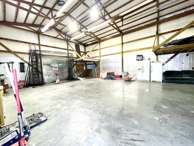 garage with electric panel, white refrigerator with ice dispenser, metal wall, and freestanding refrigerator