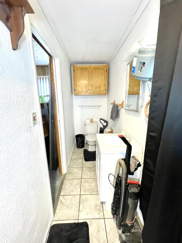 clothes washing area featuring light tile patterned floors and baseboards