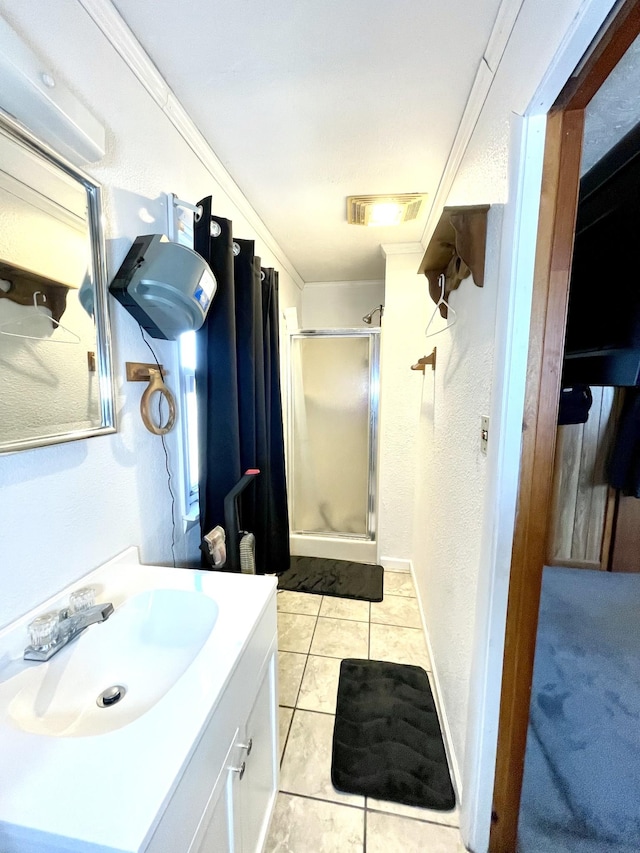 bathroom with tile patterned floors, visible vents, a stall shower, baseboards, and vanity