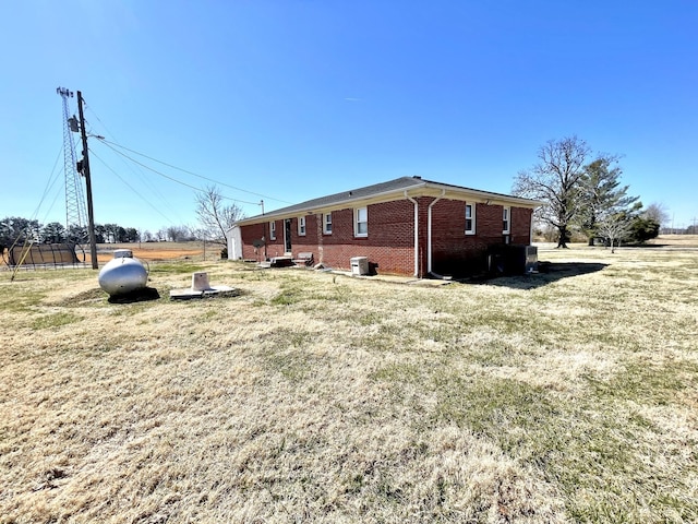 view of home's exterior with a lawn and brick siding