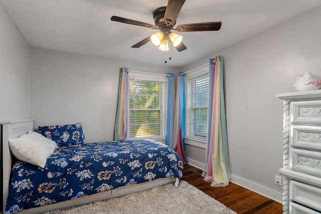 bedroom featuring ceiling fan, baseboards, and wood finished floors