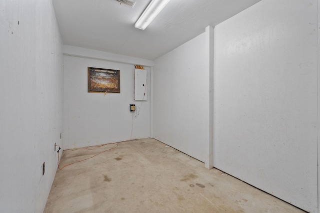 spare room featuring electric panel and concrete floors