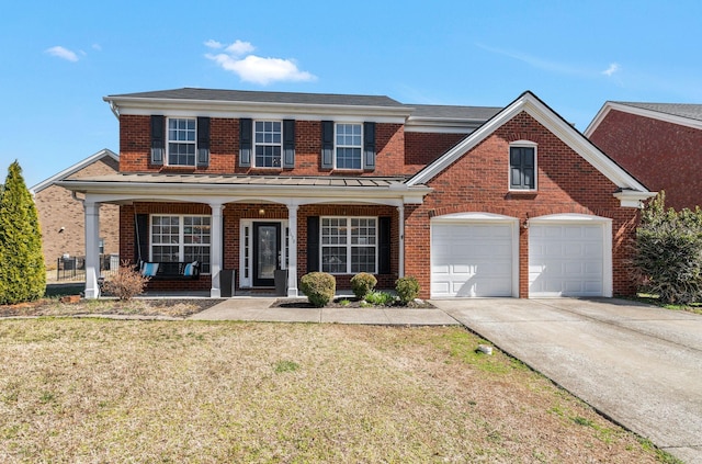 traditional home with driveway, brick siding, a porch, and a front yard