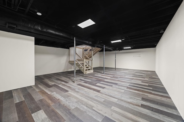 finished basement featuring stairs and wood finished floors