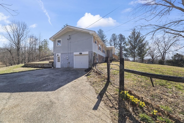 view of property exterior featuring aphalt driveway and a garage