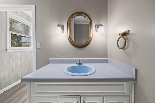 bathroom with vanity, wood finished floors, and baseboards