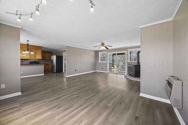 unfurnished living room featuring heating unit, a textured ceiling, dark wood finished floors, and ceiling fan with notable chandelier