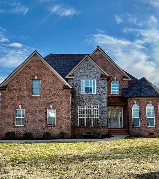 traditional-style house featuring a front lawn, brick siding, roof with shingles, and crawl space