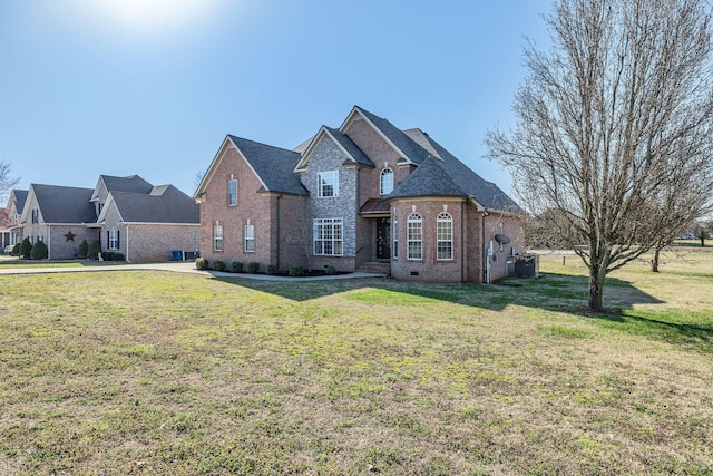 view of front of house featuring crawl space, brick siding, and a front lawn