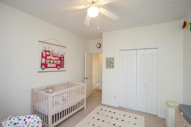 bedroom with baseboards, light colored carpet, a closet, and ceiling fan